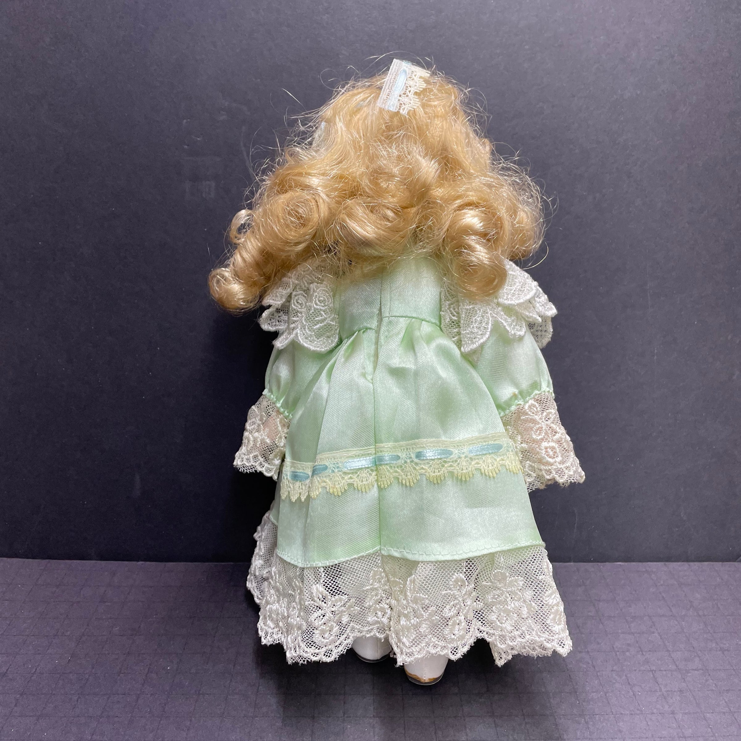 Hollylane Blue Eyes, Blond Hair, Green Dress Porcelain Doll | Thrift Harbor